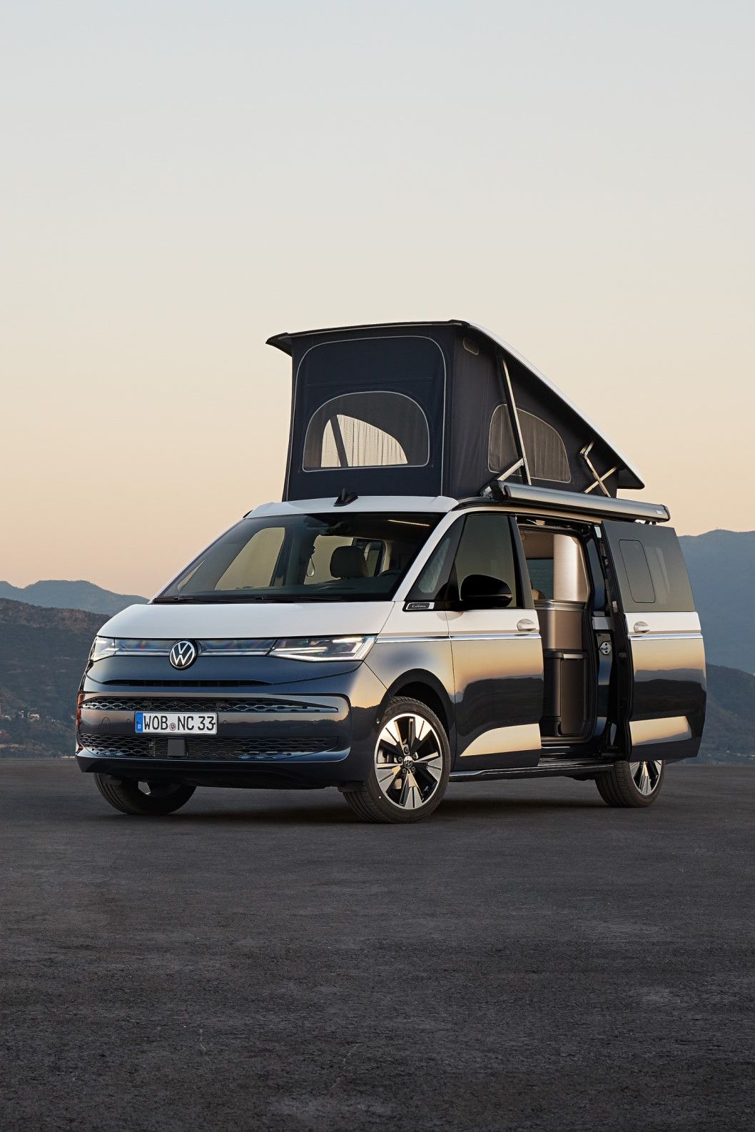 Dois veículos Volkswagen California, ambos com o teto elevado e portas abertas.